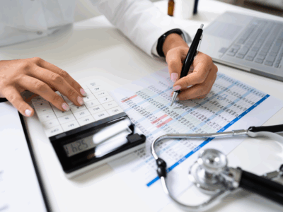 A doctor is writing on a paper with a stethoscope next to it