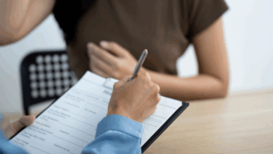 Person filling out registration form with patient