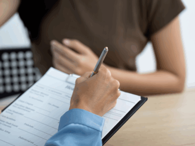 Person filling out registration form with patient