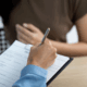 Person filling out registration form with patient