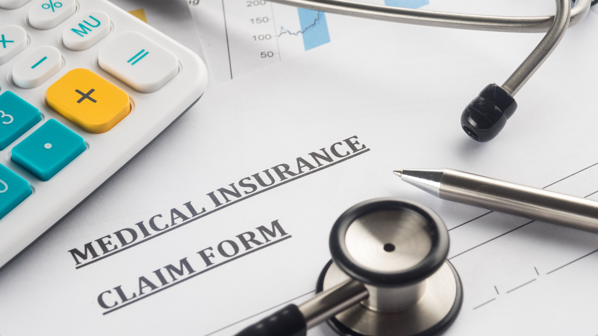 Close up of medical insurance claim form with stethoscope and calculator
